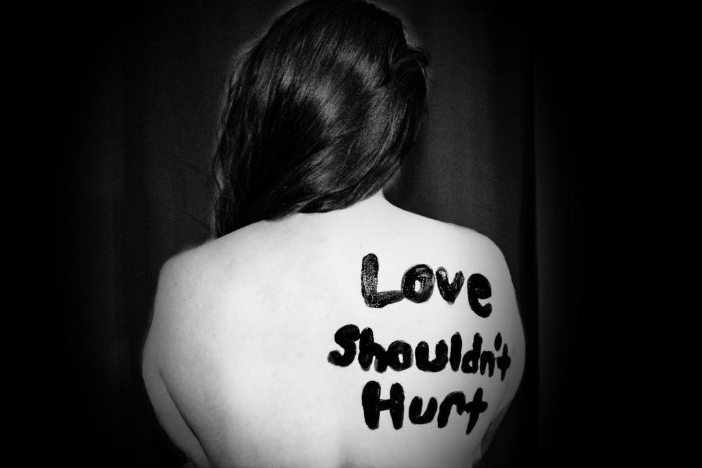 "Love shouldn't hurt" painted on back